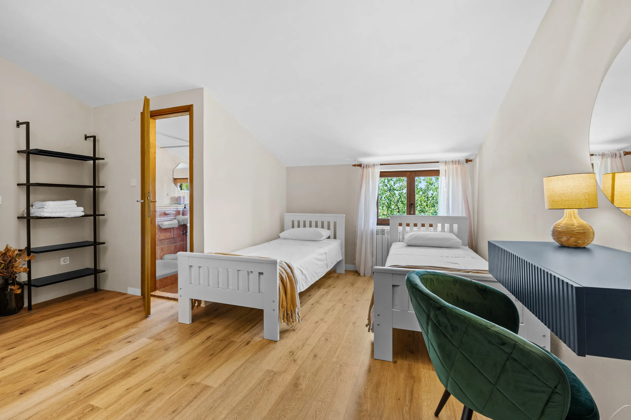 Weißes Doppelzimmer mit Holzboden im Morgenlicht