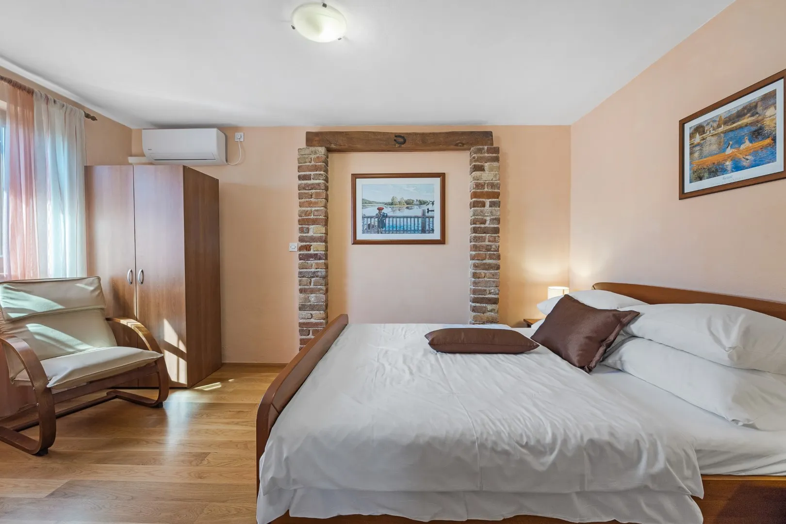 Ein Doppelbett in einer backsteingerahmten Nische, die Wände in Apricot