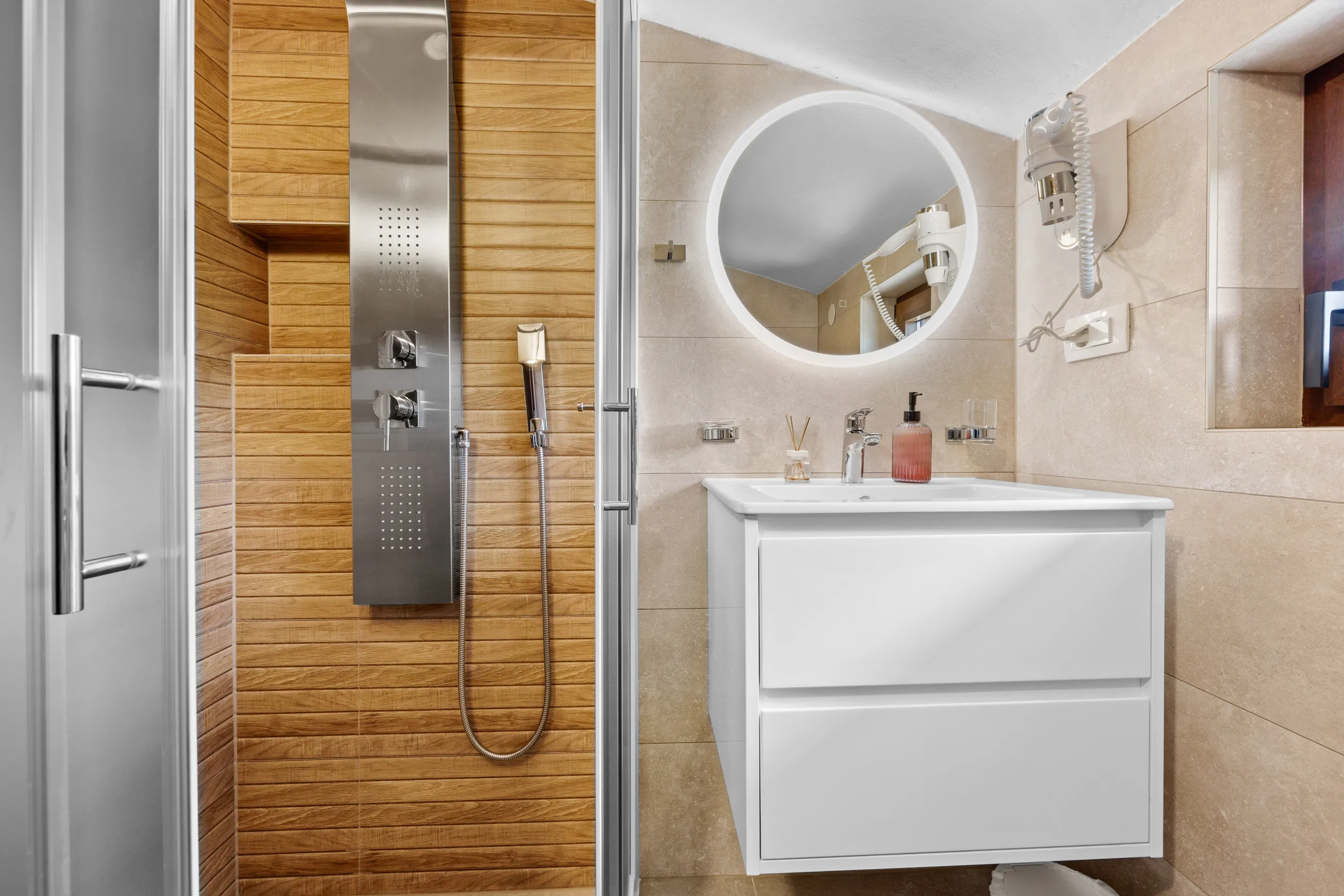 Badezimmer mit Doppelwaschtisch, ebenerdiger Dusche und holzvertäfelter Wand